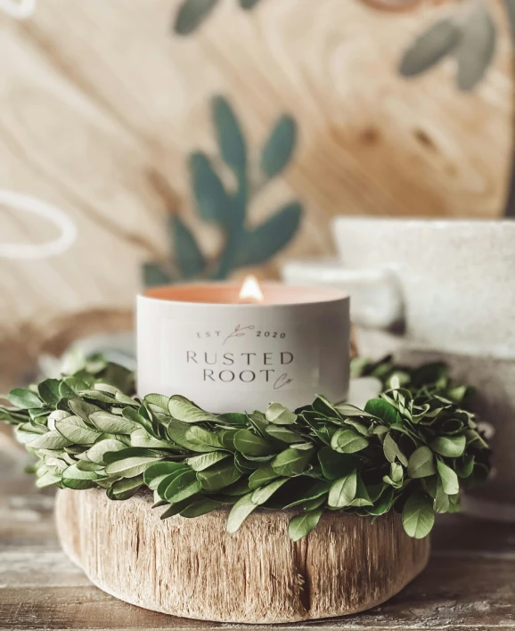 a coffee cup on a log with greenery surrounding it