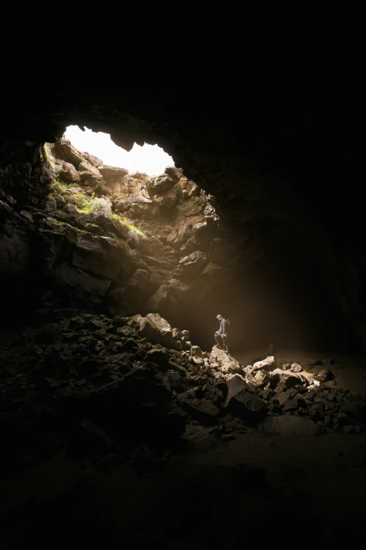 a person is standing in the light at the end of a cave