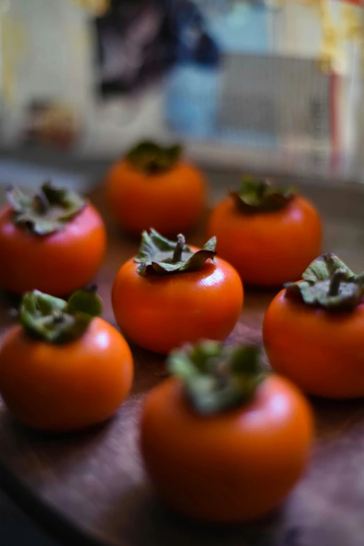 small tomatoes sitting on a  board, on top of a wooden table