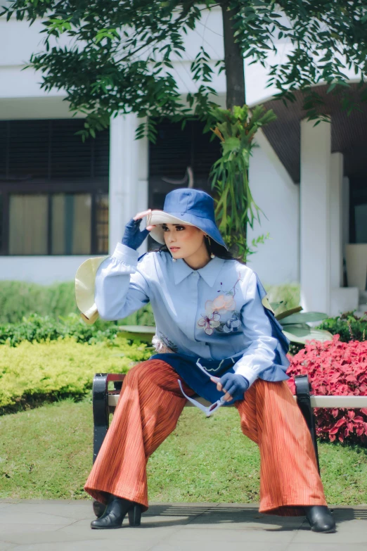 woman sitting on a park bench wearing blue and orange clothes