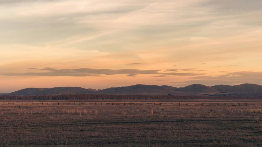 there are mountains in the background, while the sky is cloudy