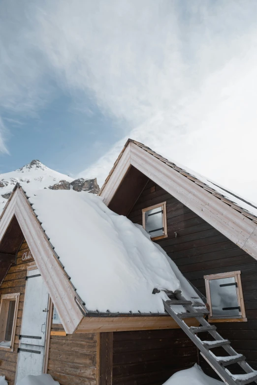 the roof is covered with snow next to a wooden house