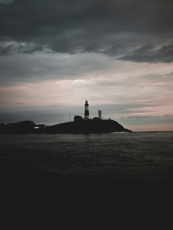 a lighthouse on top of a island in the ocean