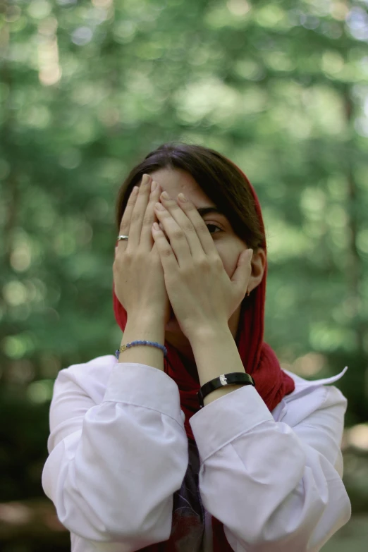 the woman wearing white is covering her eyes with her hands