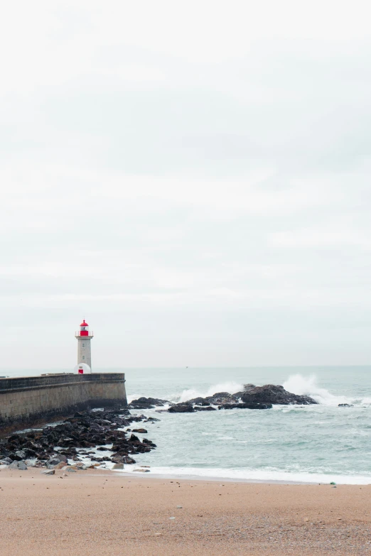 the waves break on the shore near the light house