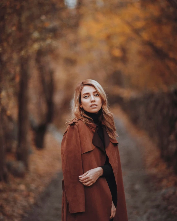 a woman with blond hair, standing in the woods