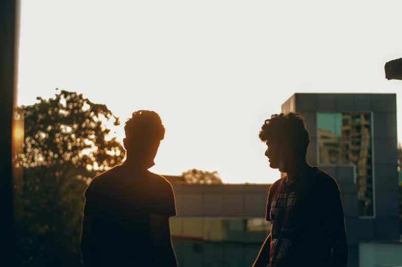 two people, one with curly hair and the other short, are looking at soing