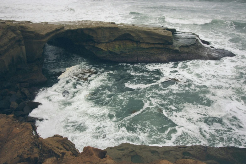an ocean cave, with waves crashing into the shore