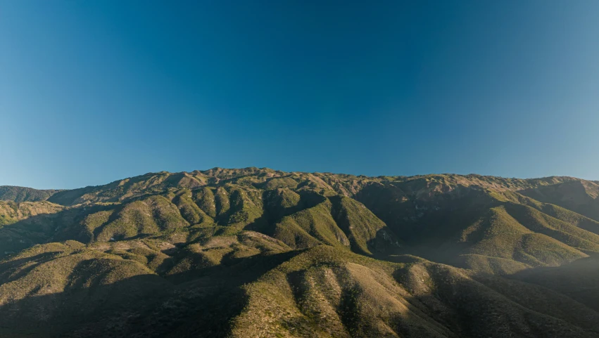 a view of some mountains with a clear blue sky