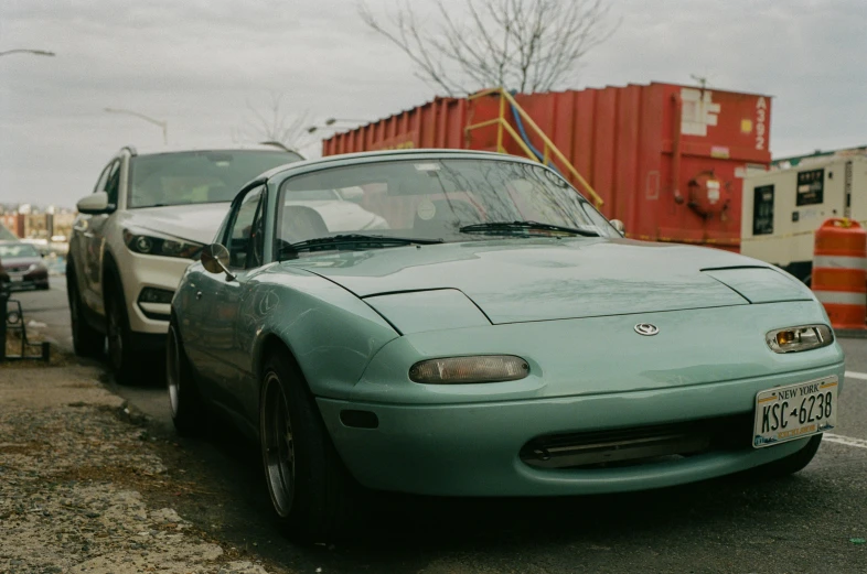 the car is parked beside the cargo container