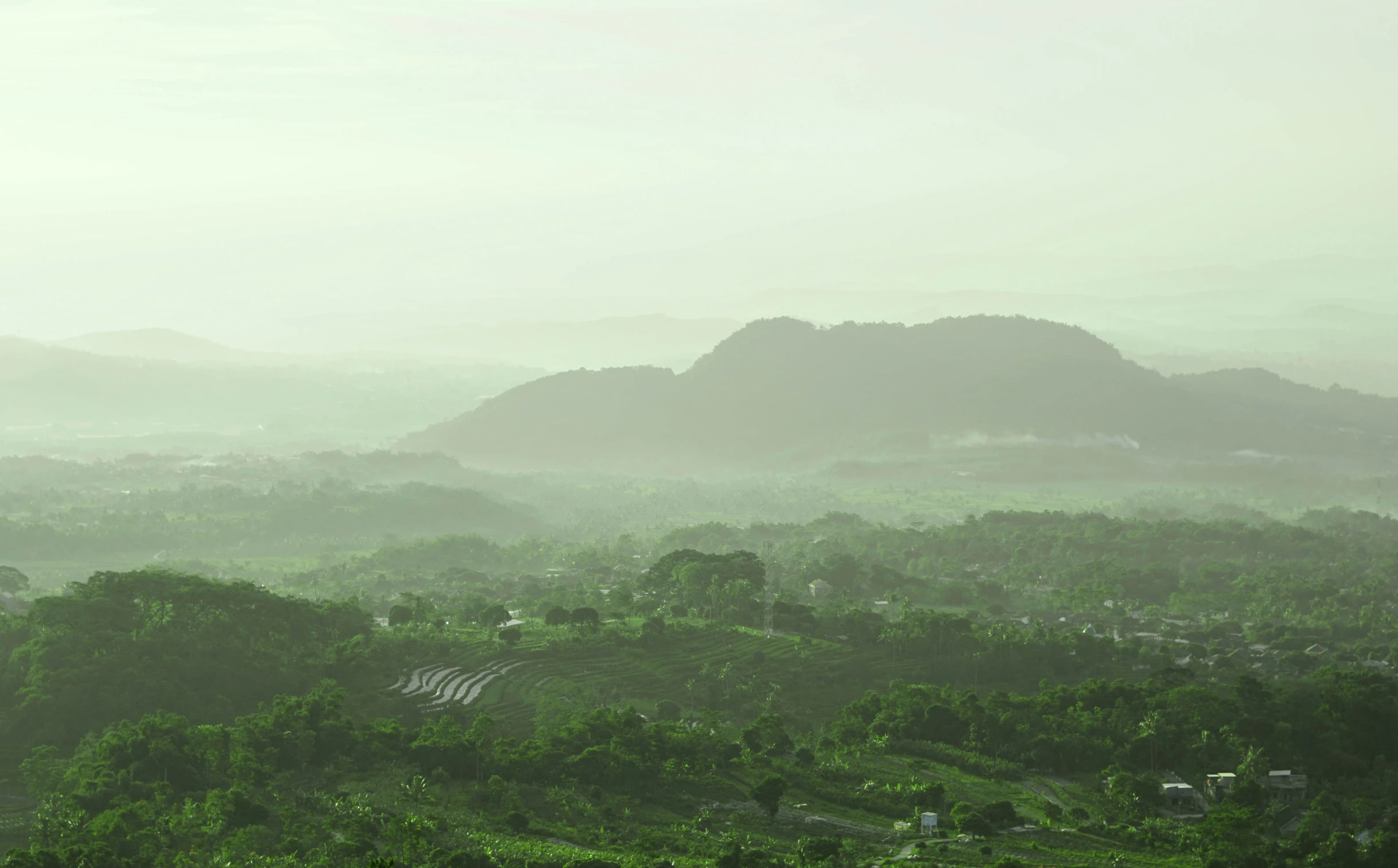 a rural area of land with trees and mountains