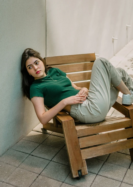 the young woman is sitting on the wooden bench