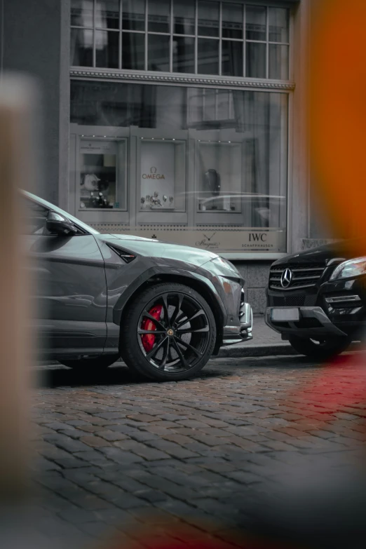 two new model cars parked side by side in front of the store