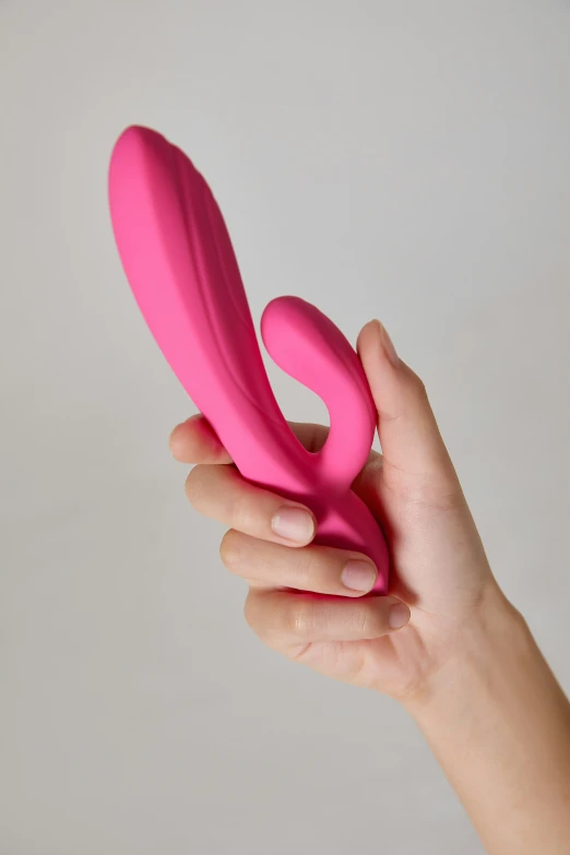 a hand holding a pink toy with its end extended
