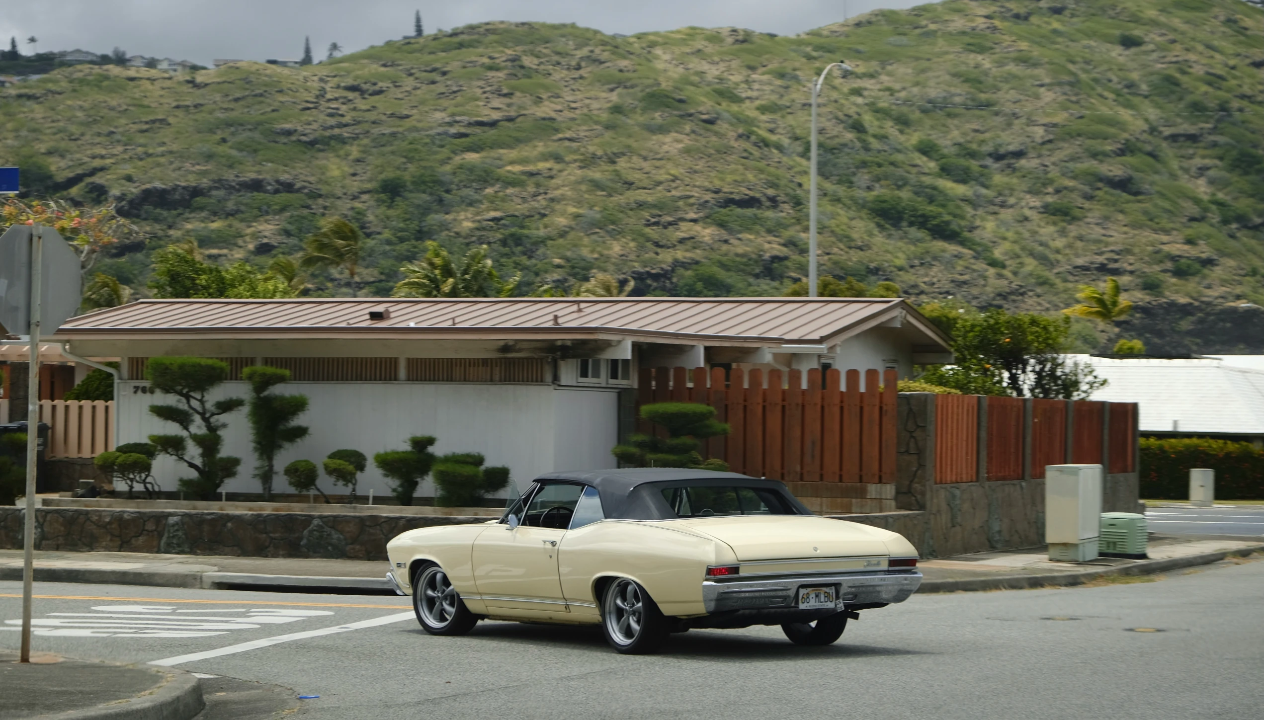 a car drives down the street past a house