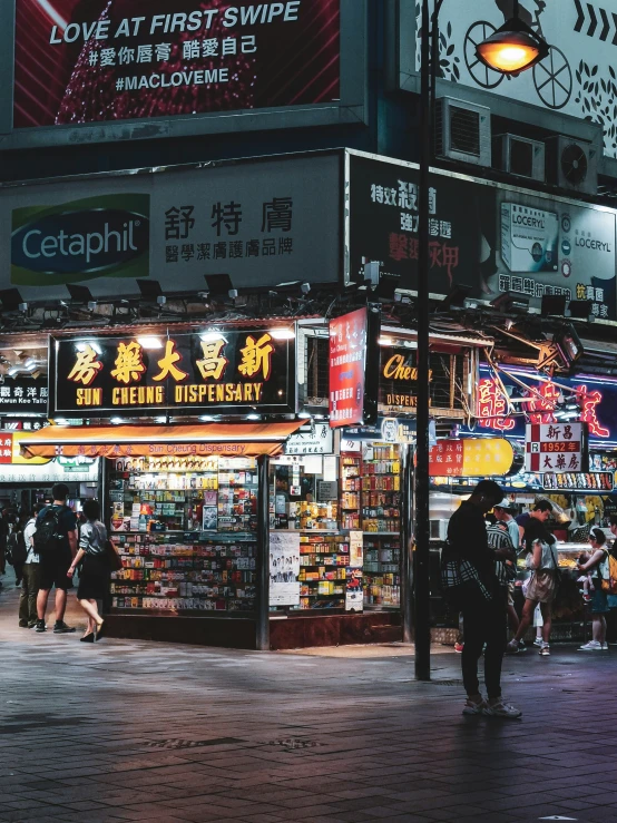 many people walk by shops in the city at night