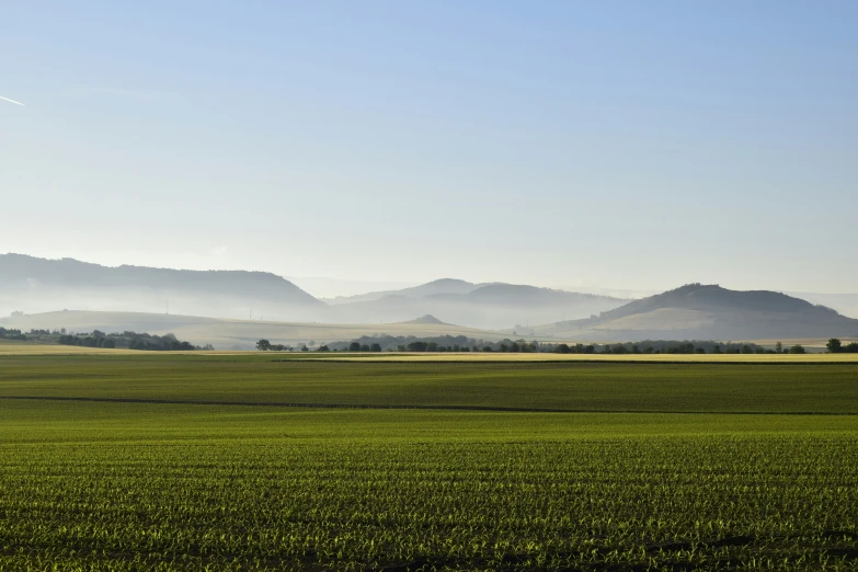 some mountains and fields that are in the day