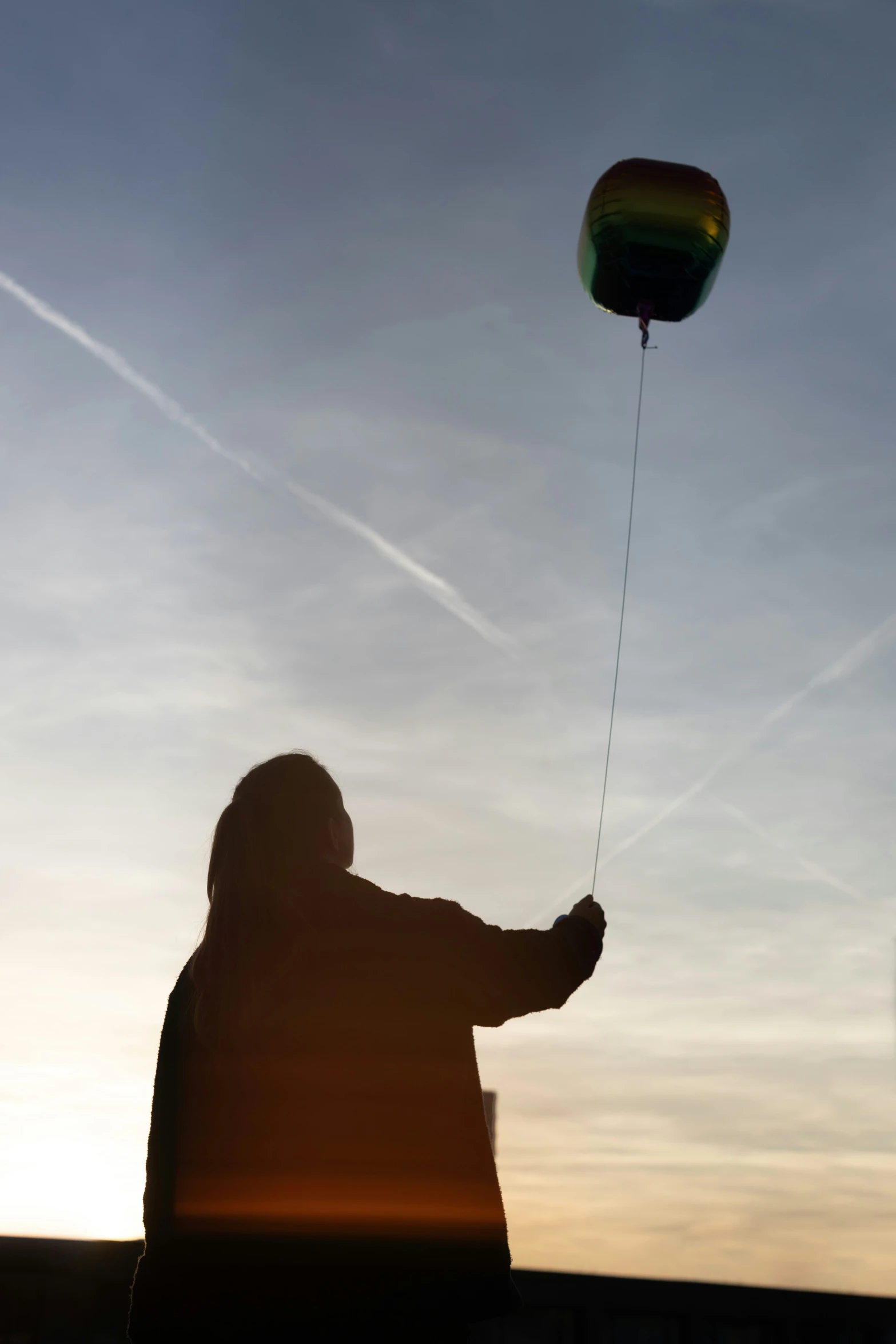 a person in a coat holding onto a kite