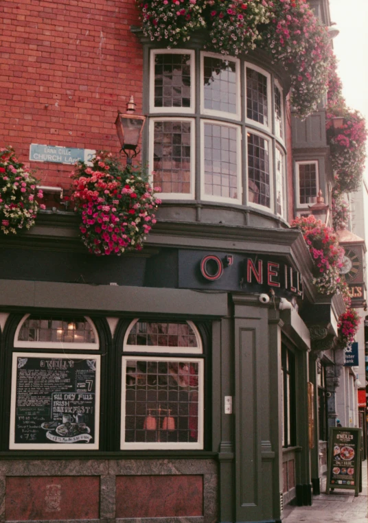 the entrance to a pub that has plants on the wall and a window above the front door