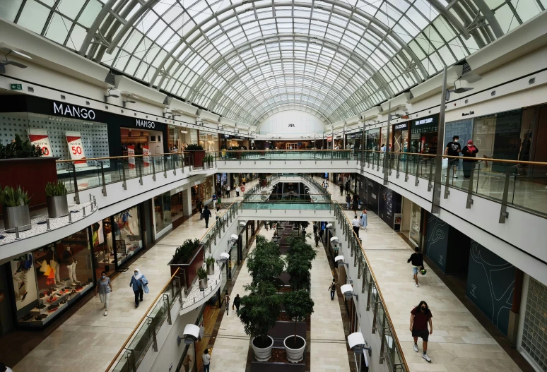 a mall with multiple levels covered in glass ceilinging