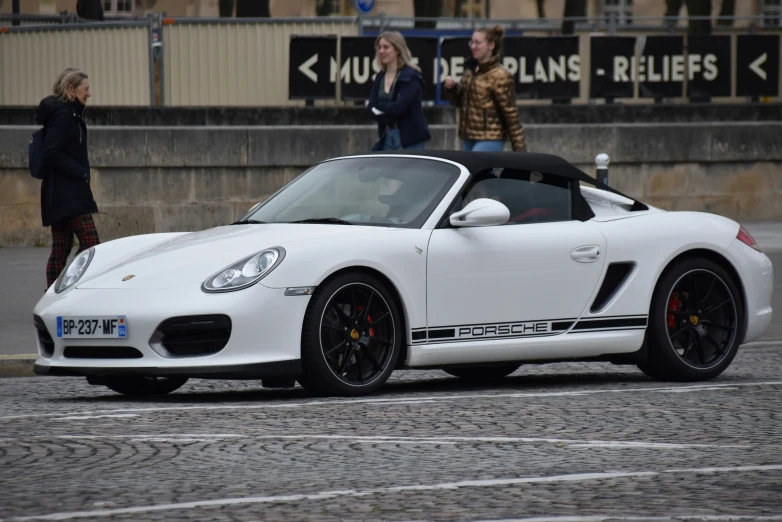 a white sports car driving down a road