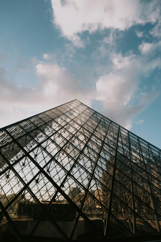 a pyramid standing alone with the sky in the background