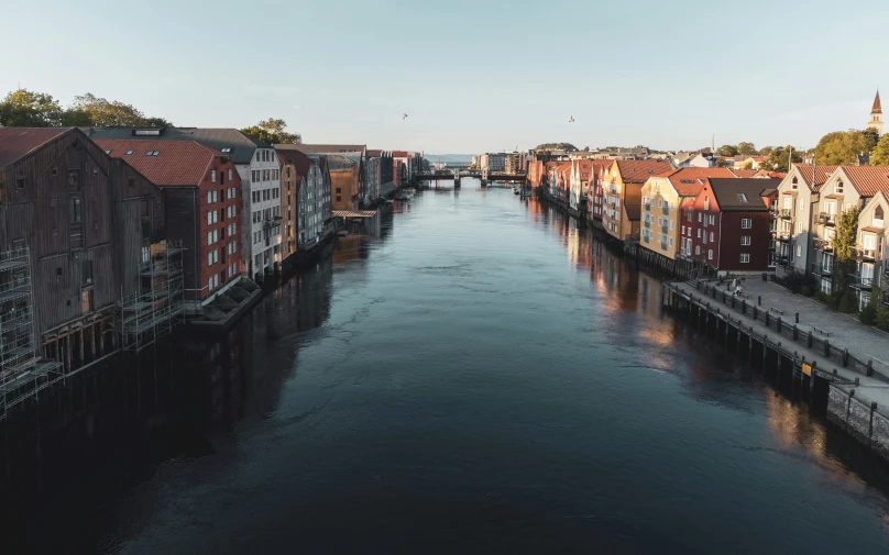 a boat traveling along a river next to tall brick buildings