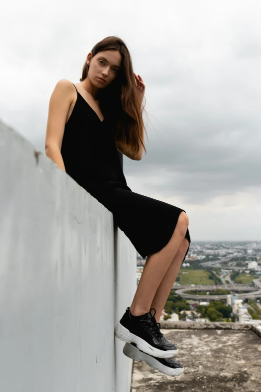 a girl is sitting on the ledge of a building