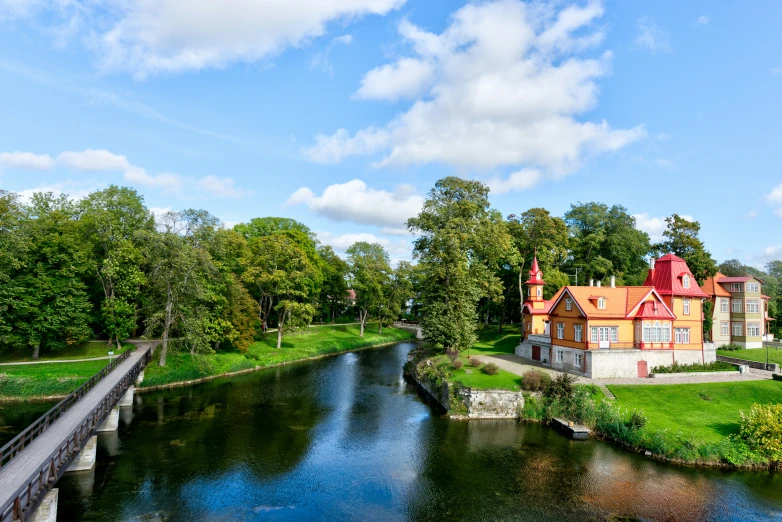 a house next to a small river with a bridge