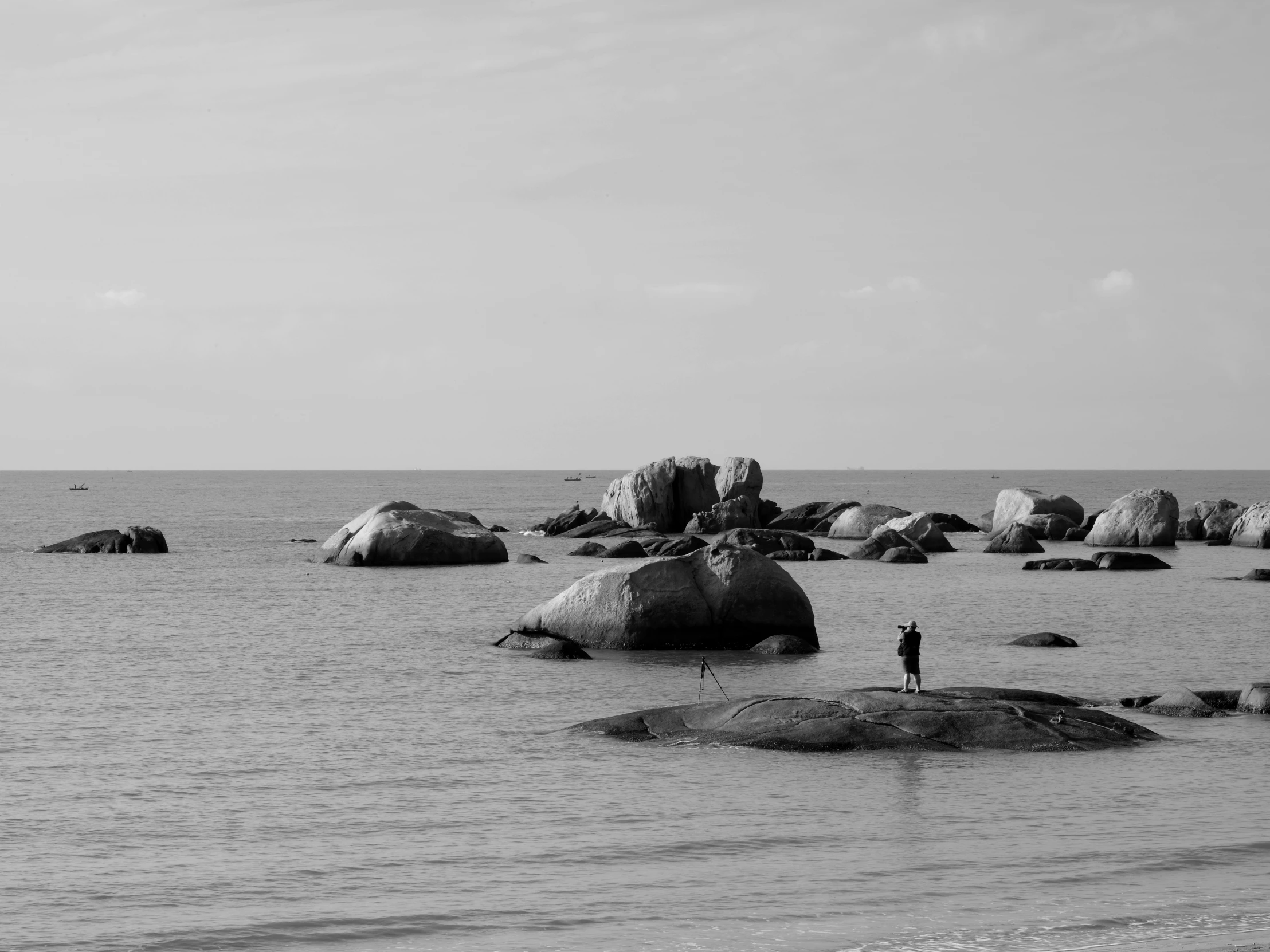 a man standing in the water on some rocks