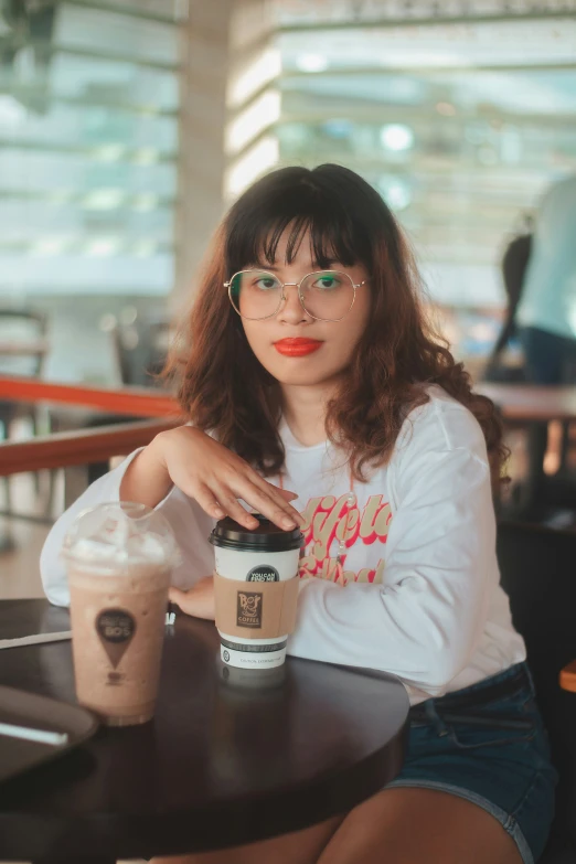 a woman is sitting at a table with a coffee