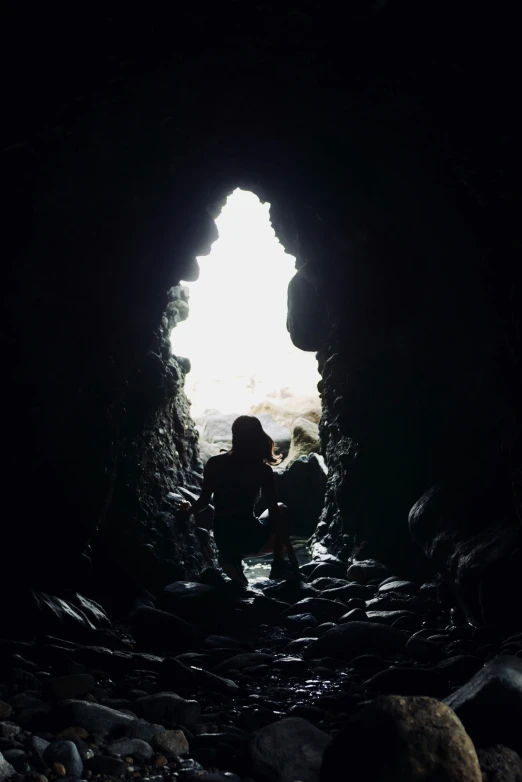 two people sitting in the dark of the cave