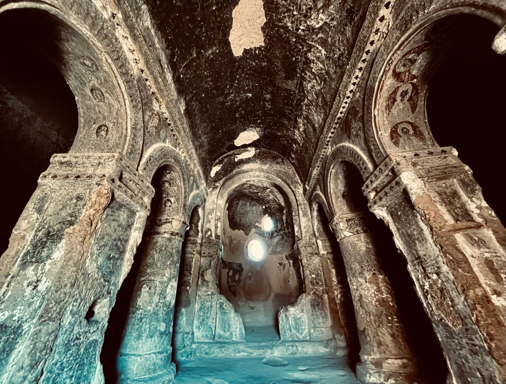 a room with stone arches, ceiling and walls