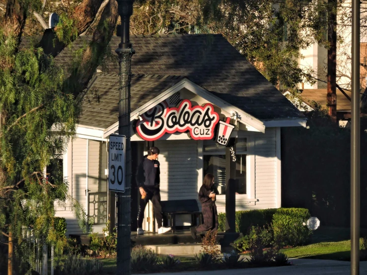 two men with letters on their bodies stand outside a house