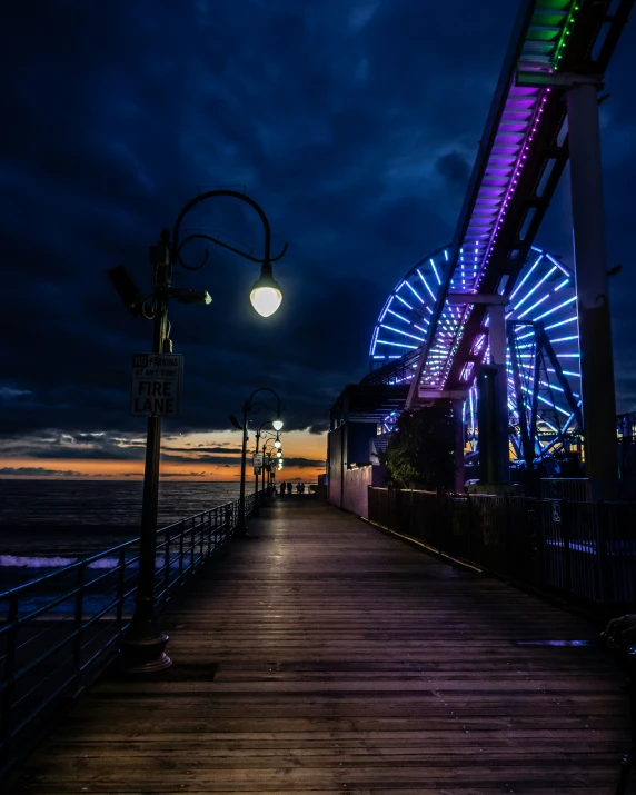 a boardwalk that has lights on at night time