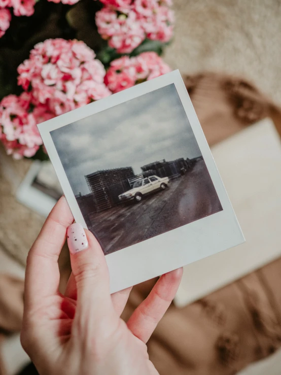 a small po of someone holding up the polaroid