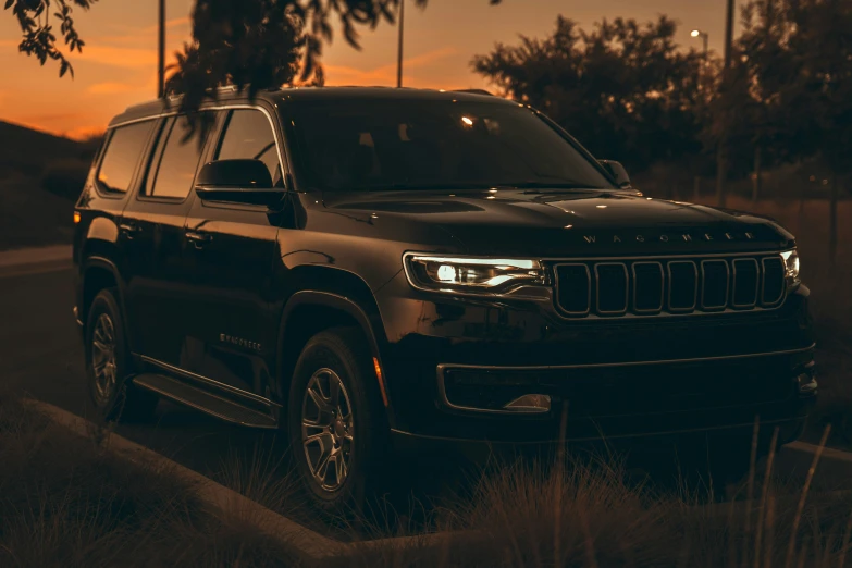 a black jeep is parked at dusk on the street