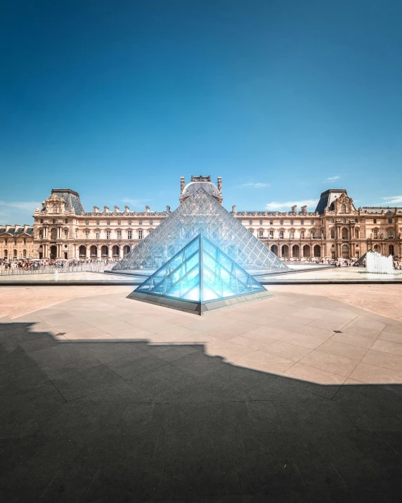 a pyramid shaped sculpture stands in front of a building