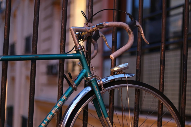 an old rusted bike locked to a gate