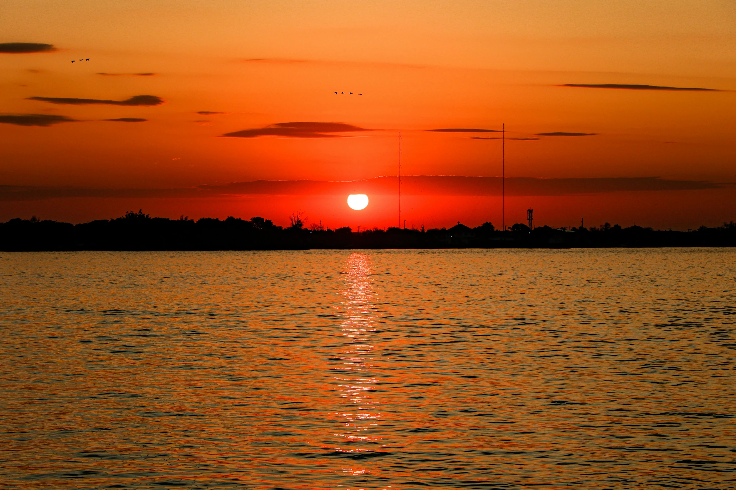 a large body of water under a red sky