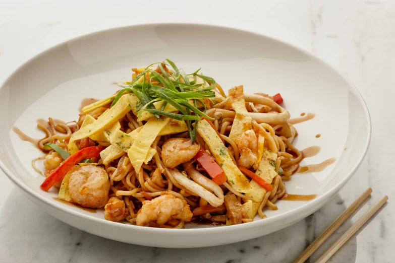 a bowl of noodles with chicken, greens and noodles