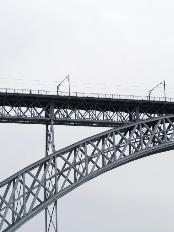 an airplane is flying past a tall bridge