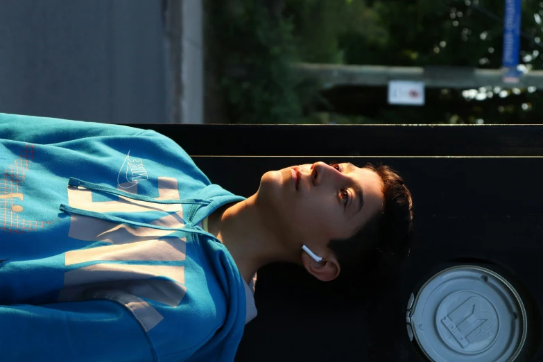 a young man resting his head against the side of a wall