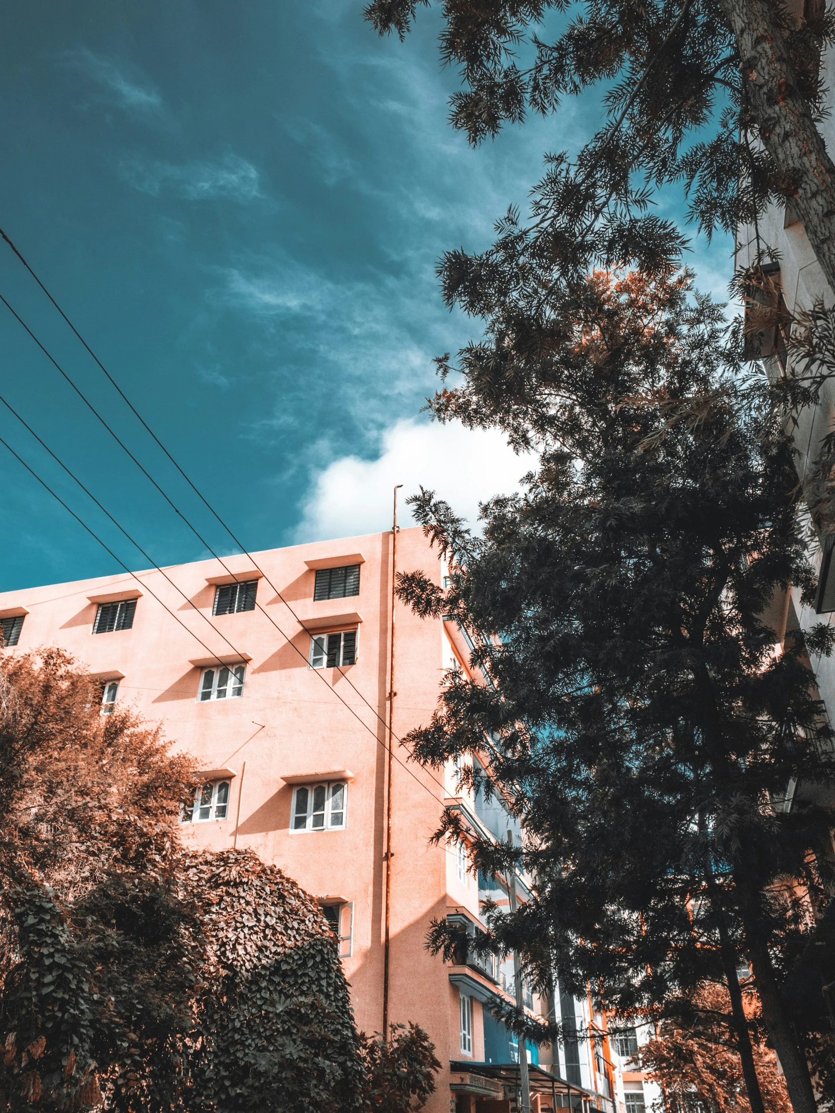 a clock sitting on top of a wooden pole near a building