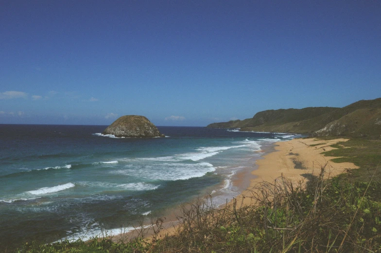 blue ocean water with cliffs and sandy beach