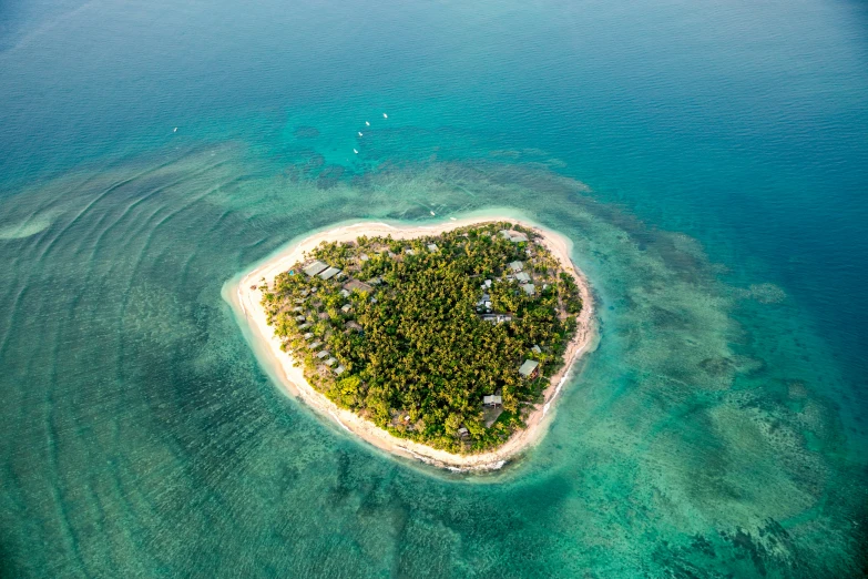 a small heart - shaped island in the middle of a blue ocean