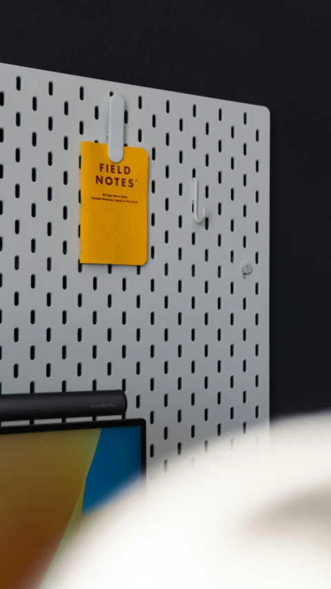 the notebook is attached to the wall and there are sticky notes pinned to it