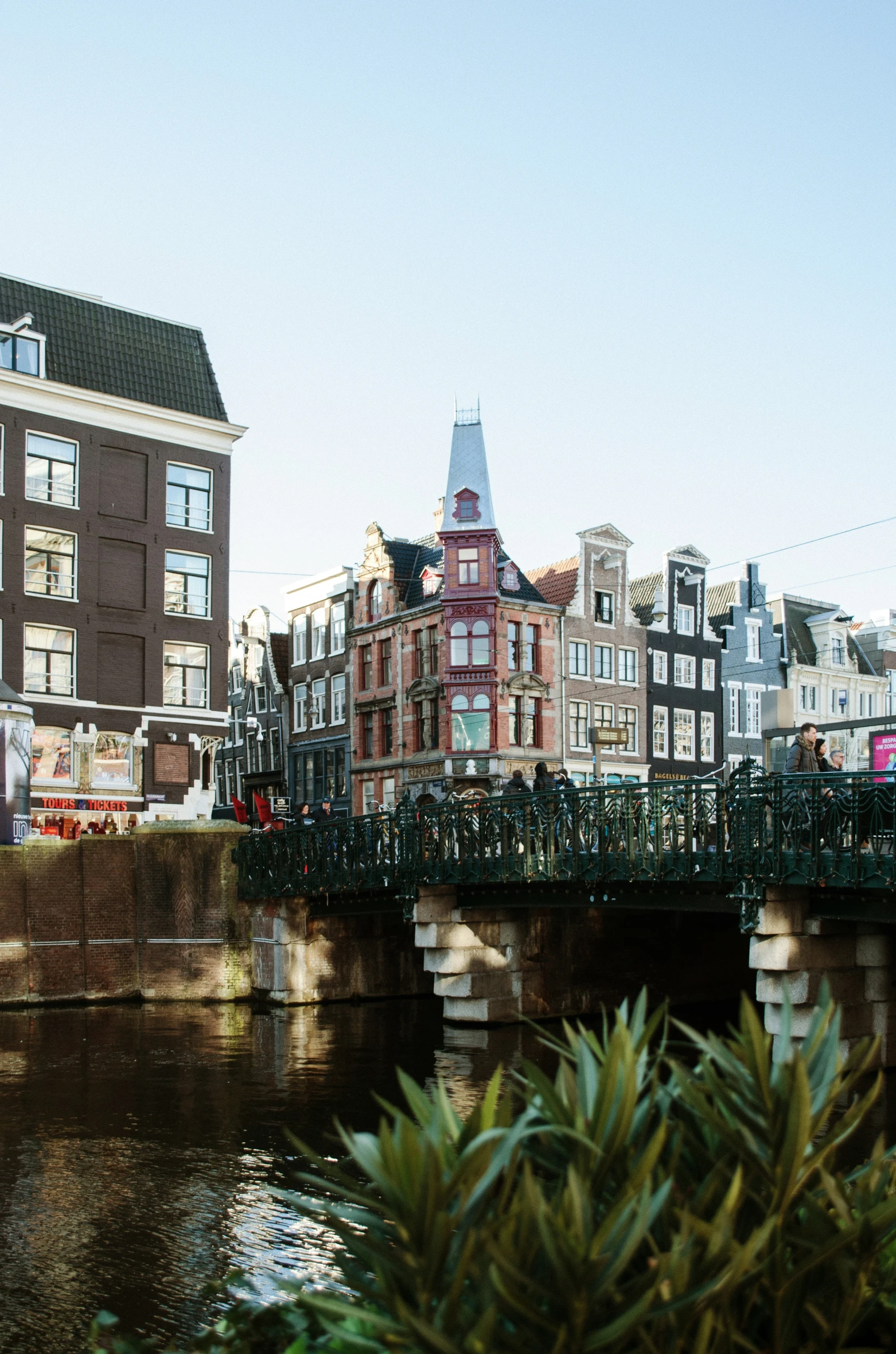 an old bridge over a city river near houses