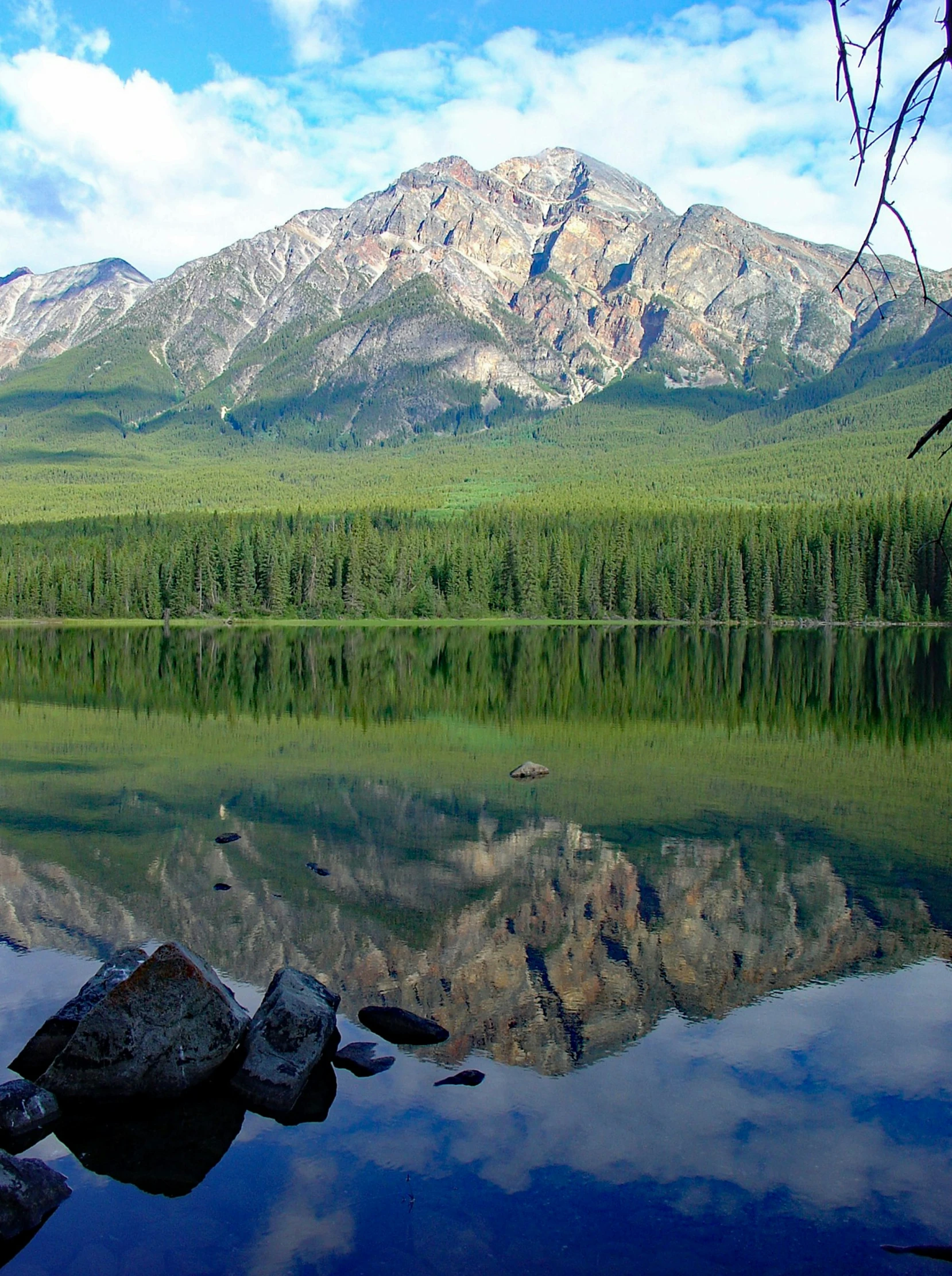 clear waters with rocks, mountains and trees in the distance