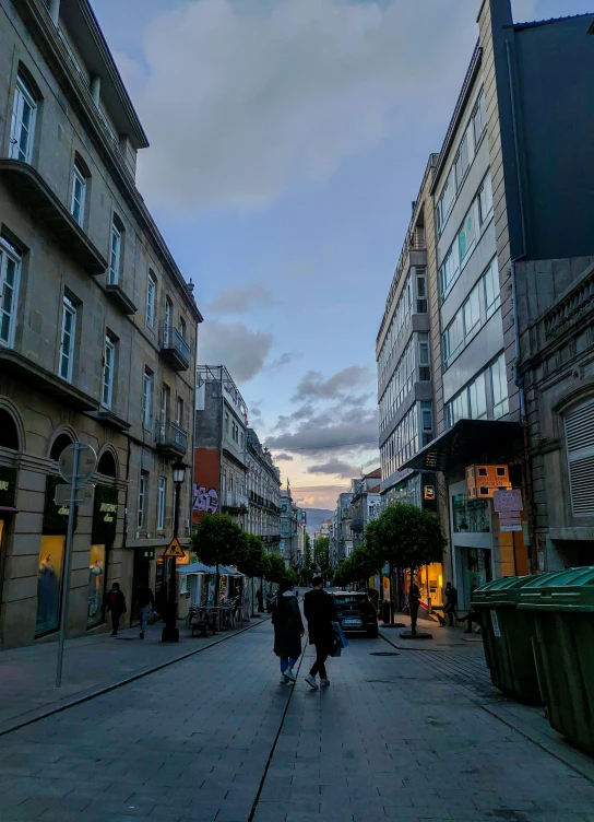 a few people walking down a street in an asian city